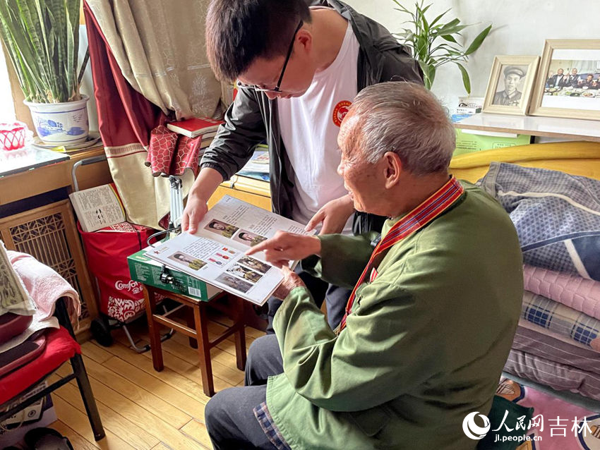 向德明向大家展示參軍時(shí)的老照片。人民網(wǎng)記者 李思玥攝