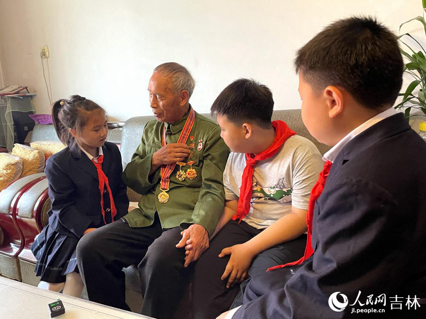 向德明同少先隊(duì)員們講述勛章背后的故事。人民網(wǎng)記者 李思玥攝
