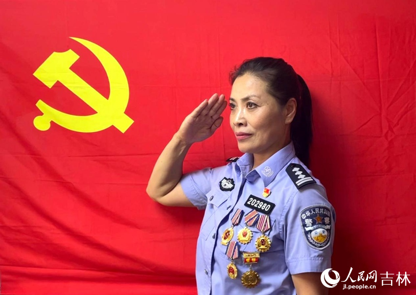 軍烈屬王永玲在黨旗下敬禮。人民網(wǎng)記者 李思玥攝