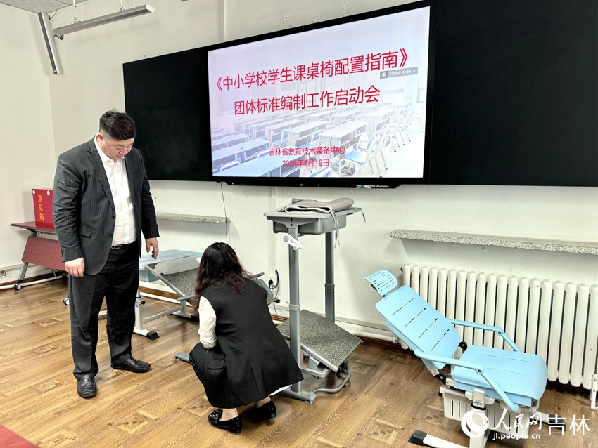 政協(xié)委員、課桌椅生產(chǎn)企業(yè)對(duì)市面上的課桌椅展開(kāi)研究討論。人民網(wǎng)記者 李思玥攝