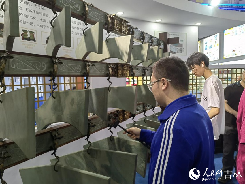 游客體驗(yàn)敲擊編磬。人民網(wǎng)記者 馬俊華攝