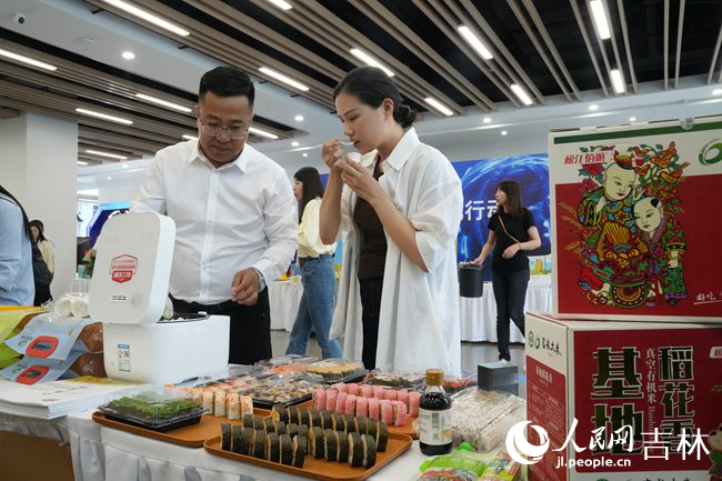 觀眾在現(xiàn)場(chǎng)品鑒長(zhǎng)春大米。人民網(wǎng)記者 李洋攝