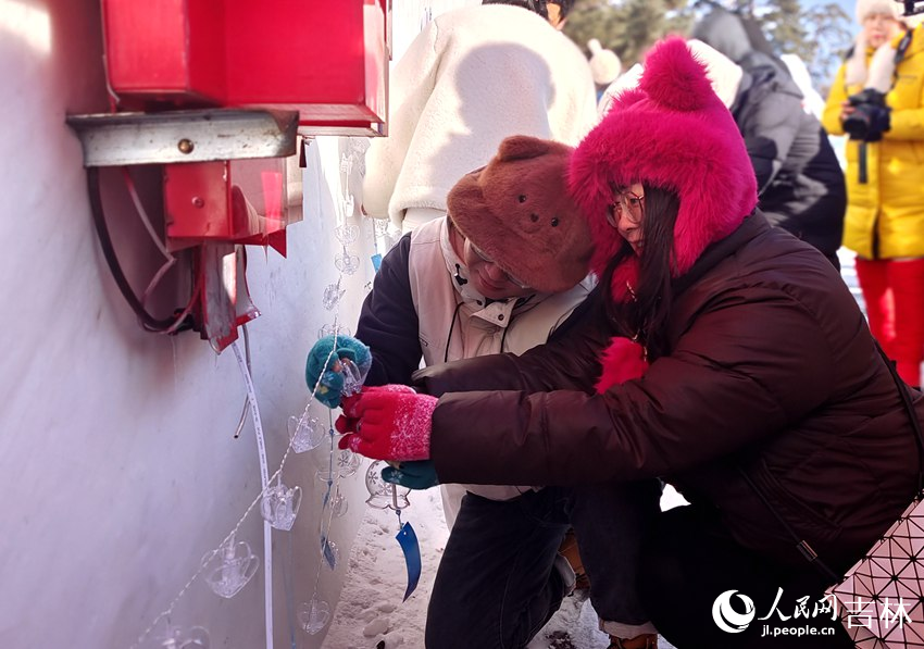 一對戀人雪花風鈴掛于美人松寄情壁上。人民網(wǎng)記者 關思聰攝