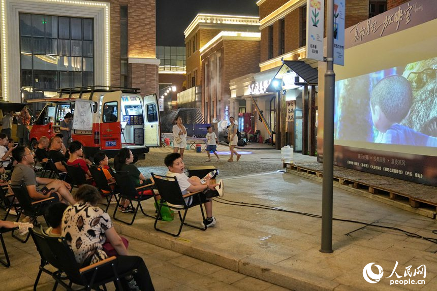游客在春京西文旅街區觀看露天電影。人民網記者 李洋攝