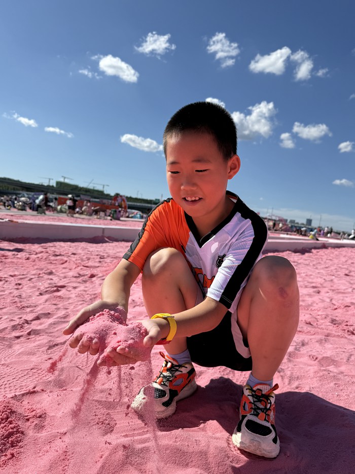 一名小朋友在肆季南河粉紅沙灘感受暑期生活的豐富多彩。人民網(wǎng)記者 李洋 攝