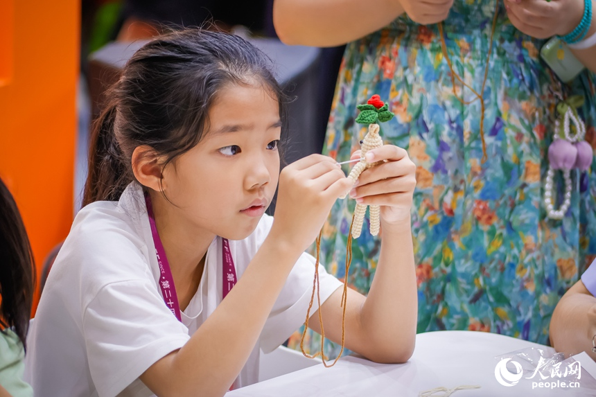 一名小朋友在“吉林巧姐”展區動手創作。人民網記者 李洋攝