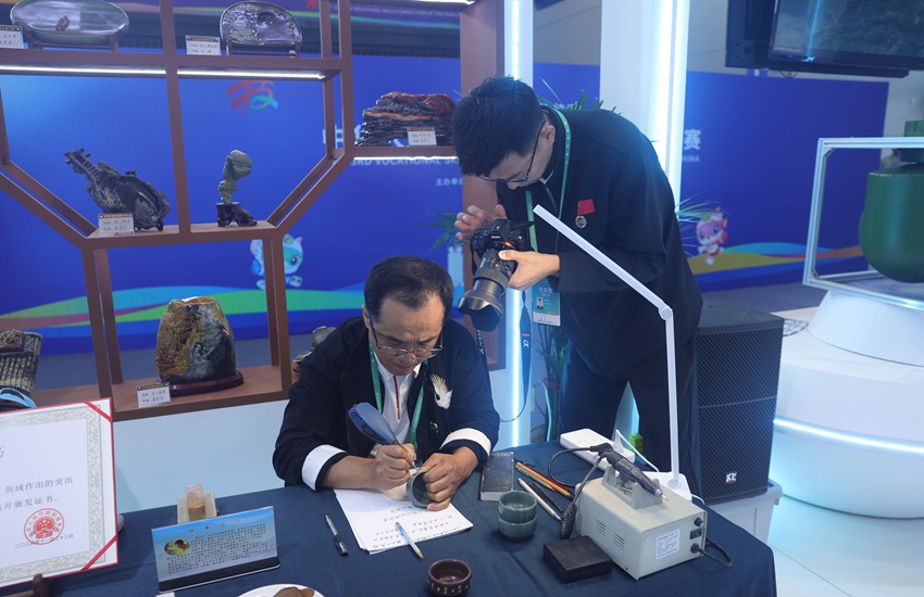 吉林省工藝美術(shù)大師、省級(jí)非遺傳承人竇茂忠認(rèn)真雕刻著手中的松花石。不一會(huì)兒工夫，一個(gè)個(gè)精美的字組成極具韻味的詞句，躍然“石”上。楊宜修攝