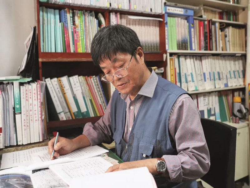 金萬春在翻閱認(rèn)真查找烈士資料