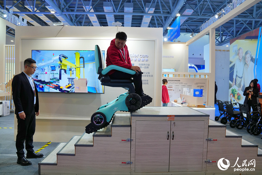 博覽會上，工作人員向觀眾展示為老年群體研發的爬樓機器人。人民網記者 李洋攝
