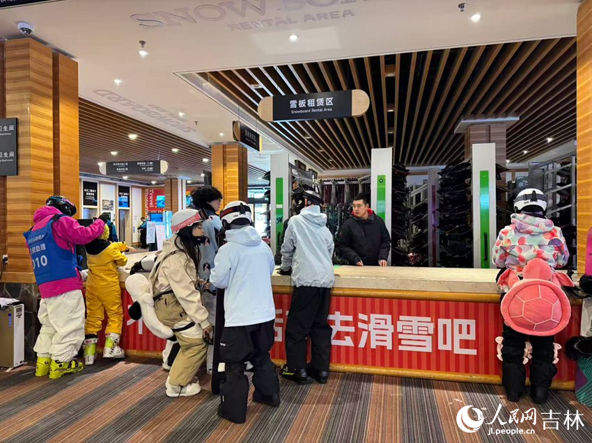 滑雪場內的雪板租賃區前，身著多彩滑雪服的游客們正在排隊等候。人民網記者 李思玥攝
