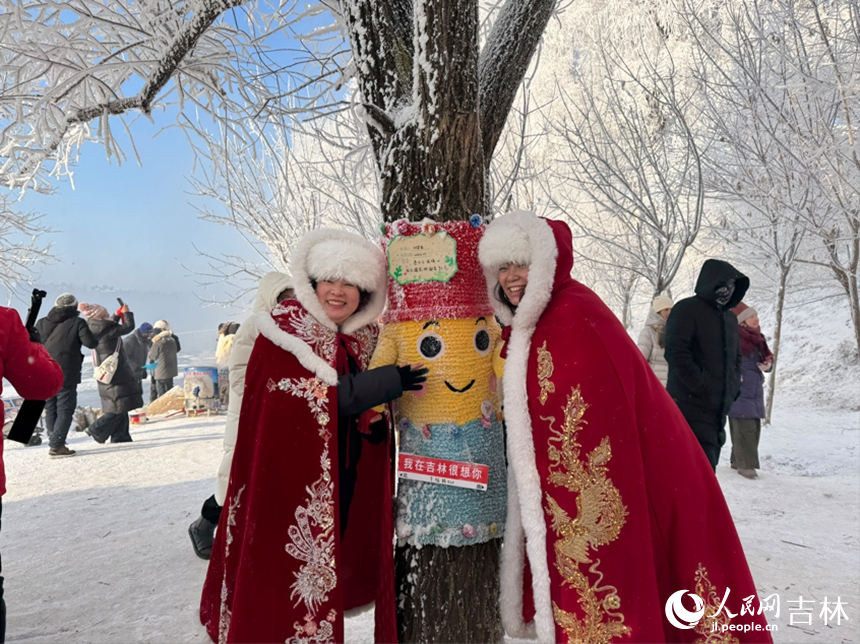 游客身披喜慶的紅色披風，圍繞著裝飾可愛的樹樁拍照留念。人民網記者 李思玥攝