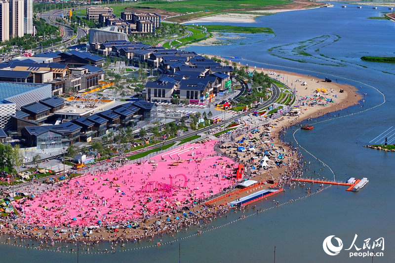 8月，長春肆季南河岸線公園的粉色沙灘人氣十足。肆季南河是長春首個濱河文旅商綜合體，項目依托“一河兩岸三橋”格局，打造多元業態于一體的潮流空間。人民網記者 李洋攝