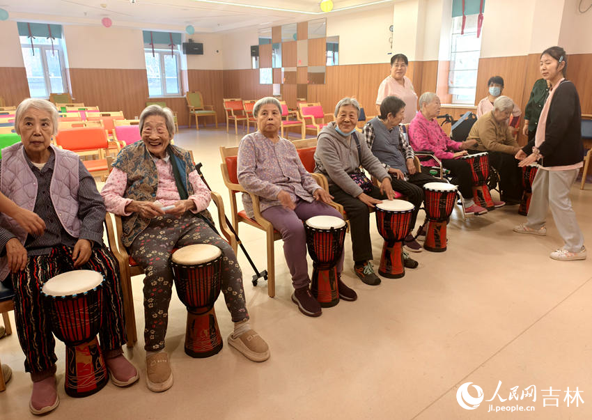 親親園養老護理康復中心，老人坐在一起學敲鼓。人民網記者 關思聰攝