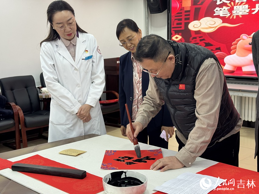 長春美術館（長春書畫院）館長趙經武為無償獻血者寫下新春“?！弊帧Ｈ嗣窬W記者 李思玥攝
