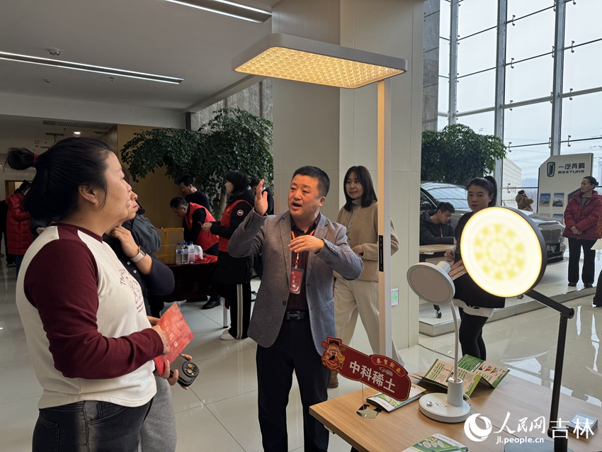 中科稀土（長春）有限責任公司的展位前，銷售總監王鴻宇為市民介紹護眼燈與普通光源的光譜差異。人民網記者 李思玥攝