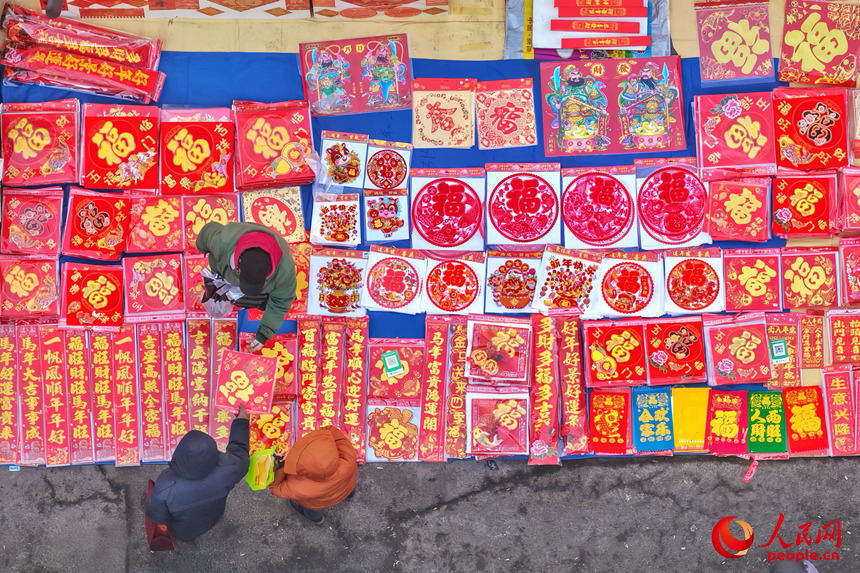 市民在大集上購(gòu)買(mǎi)喜慶的福字。人民網(wǎng)記者 李洋攝