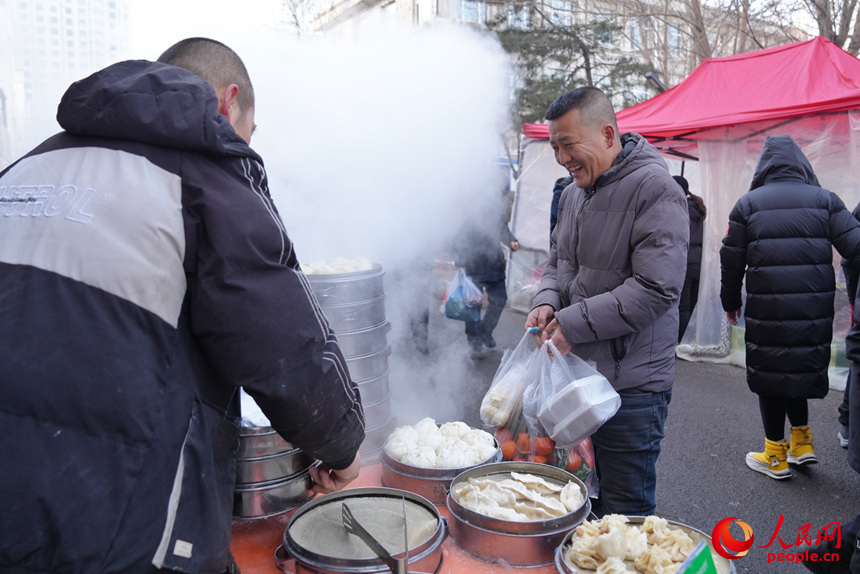 顧客在美食攤位前購(gòu)買(mǎi)剛出鍋的包子。人民網(wǎng)記者 李洋攝