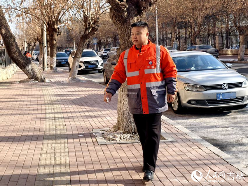 姜麗君在南關區平泉路巡查衛生情況時，隨手撿起垃圾扔到垃圾箱里。人民網記者 關思聰攝