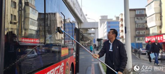 10月4日一早，吉林省長春市271路車站，司機(jī)何師傅發(fā)車前為公交車做好清潔工作，確保乘客舒心出行。人民網(wǎng)記者 王帝元攝